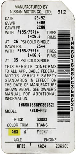 Close-up of Nissan paint code label on a vehicle door jamb
