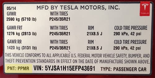 Close-up of Tesla paint code label on a vehicle door jamb